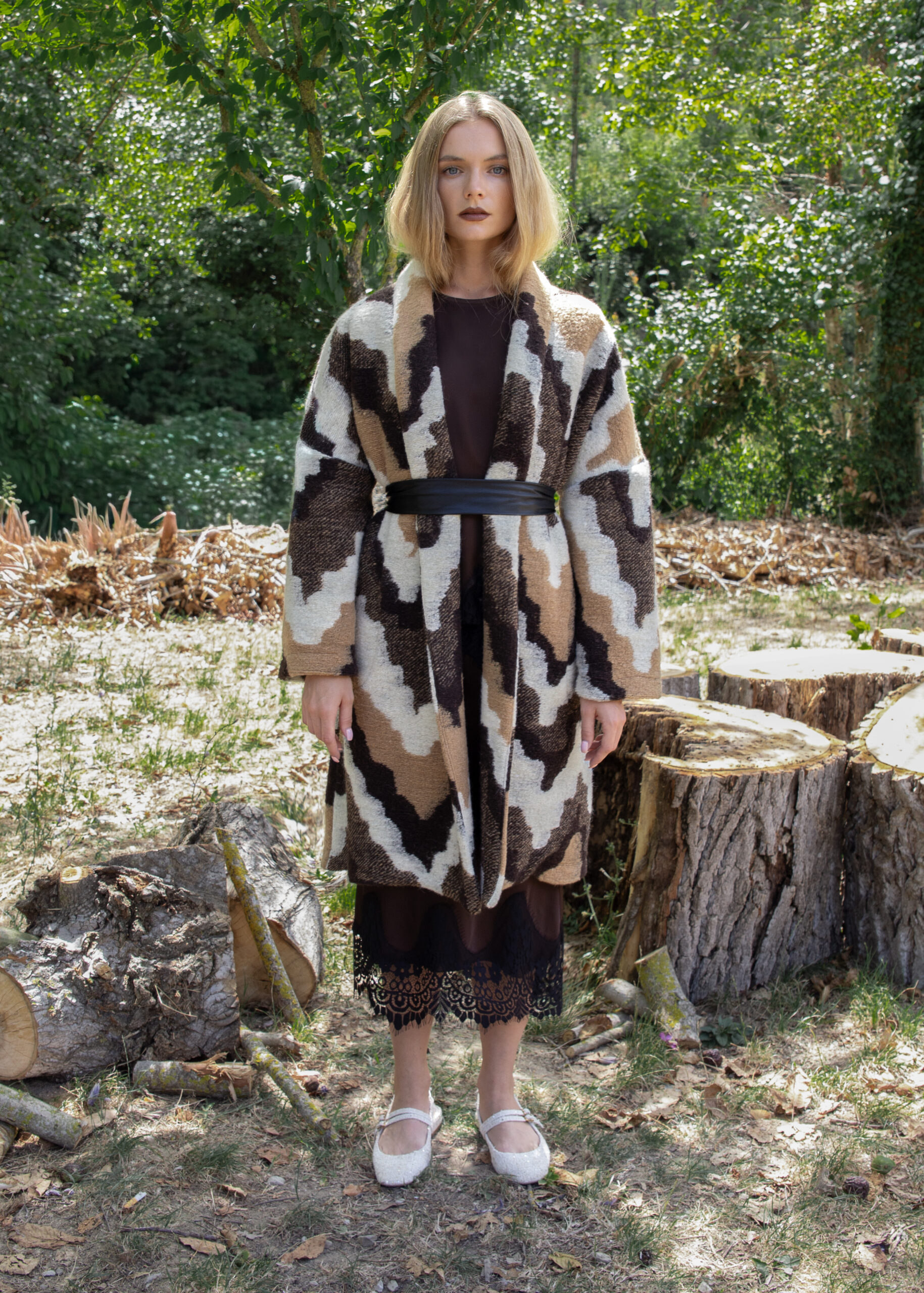 Oversized coat with abstract earth-tone pattern, shawl collar, wide sleeves and black eco-leather waist belt — Fall Winter 25